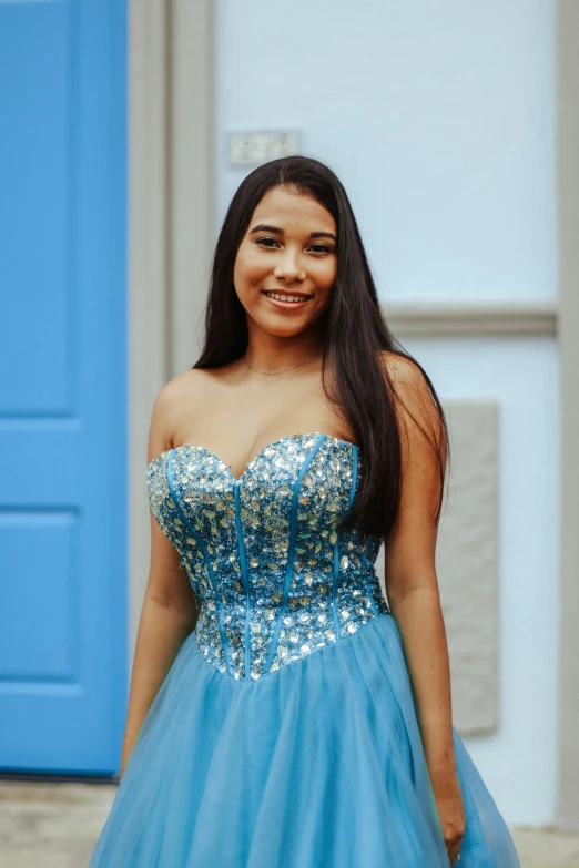 girl in a blue dress outside posing for a picture