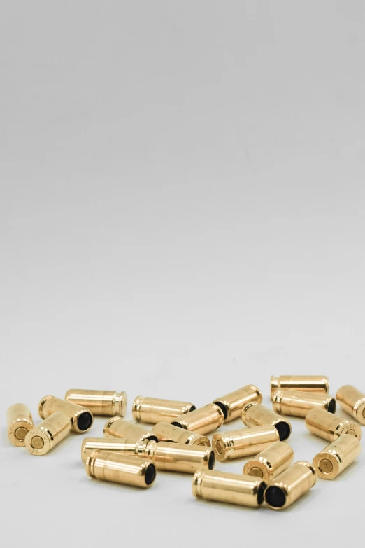 a bunch of gold bullet pieces on a white background