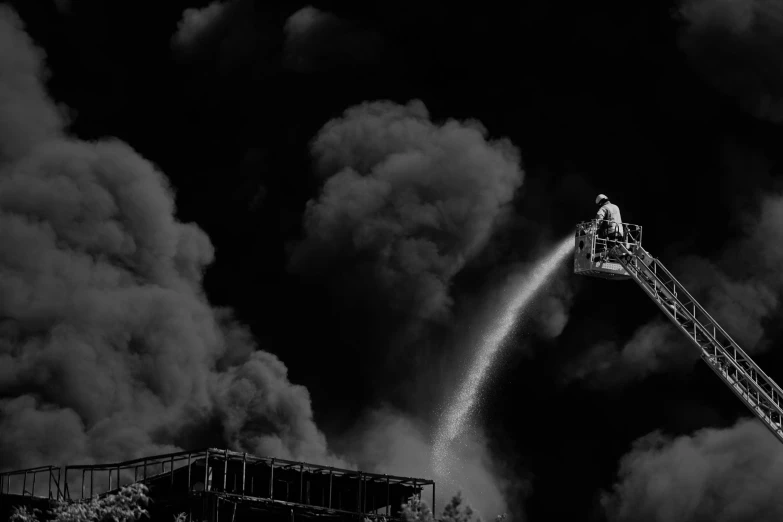 a black and white image of a firetruck spraying water on a building