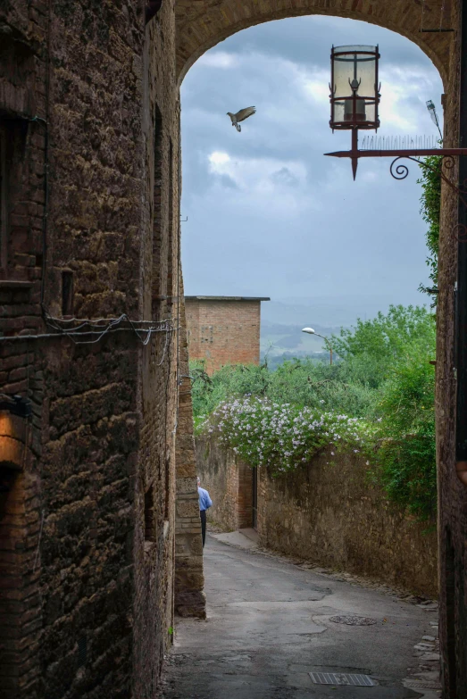 an alley way with light hanging from the ceiling and old stone buildings