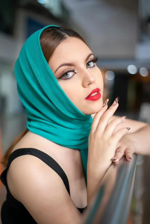 a woman in green scarf sitting with her hand over her mouth