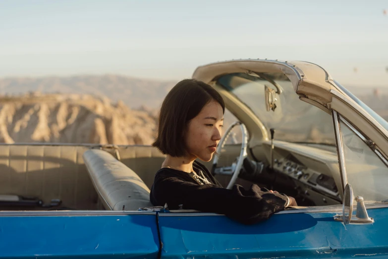 woman in car using her cell phone while sitting at the wheel