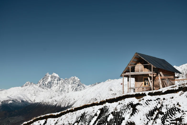 a cabin in the mountains with snow on it