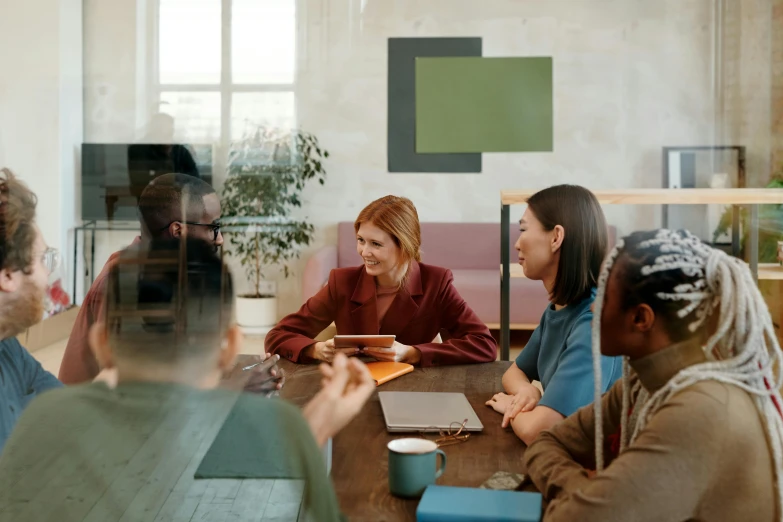 a group of people sitting around a wooden table