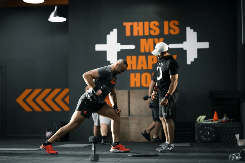 a man is kneeling on a hurdle while others stand around