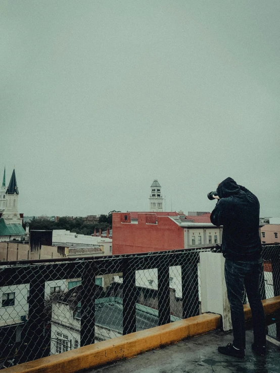 a person wearing black stands near the camera and takes pictures