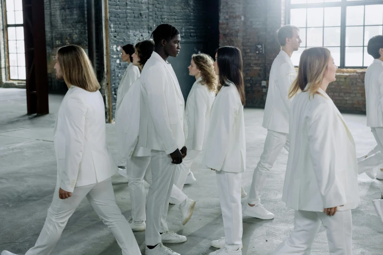 models walk down the runway in white suits