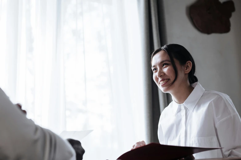 a woman smiling while holding onto a book