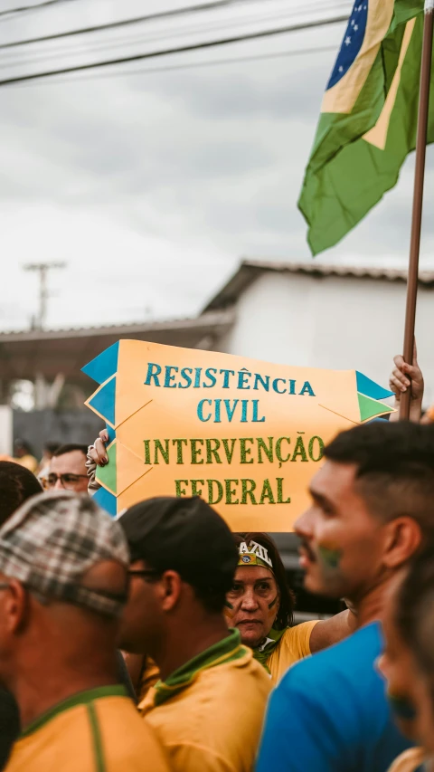 there is a man holding a sign in the middle of a crowd