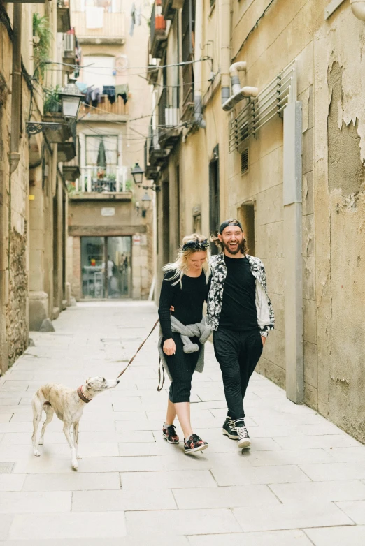 two young women and a man walking down a street holding hands