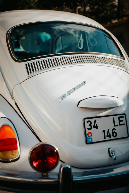 a white volkswagen beetle car with a license plate