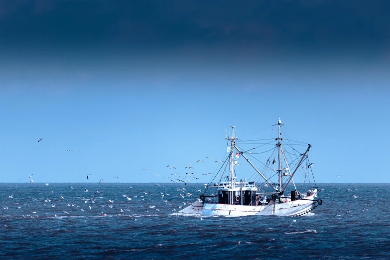 a boat in the middle of the ocean near a shore line