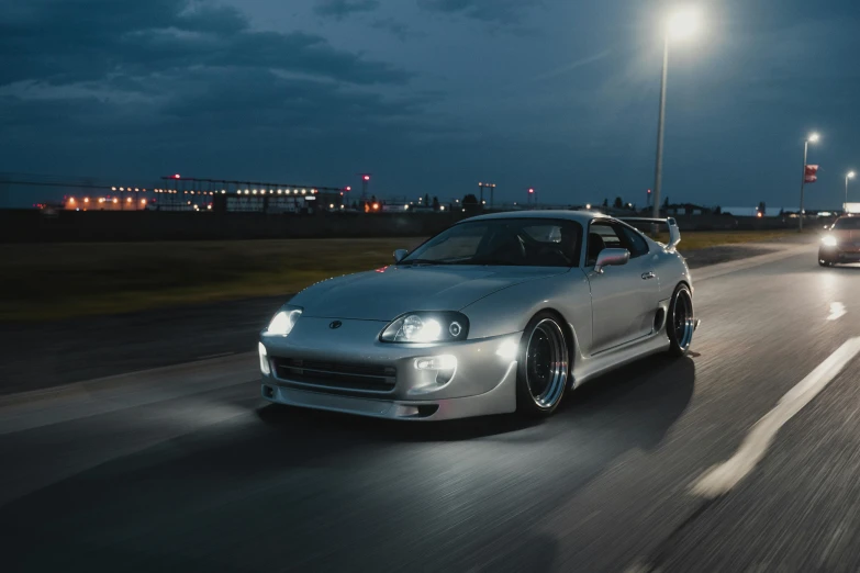 two cars traveling down a highway at night