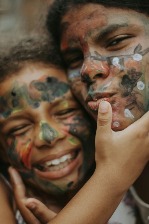 two young children with face paint on one cheek