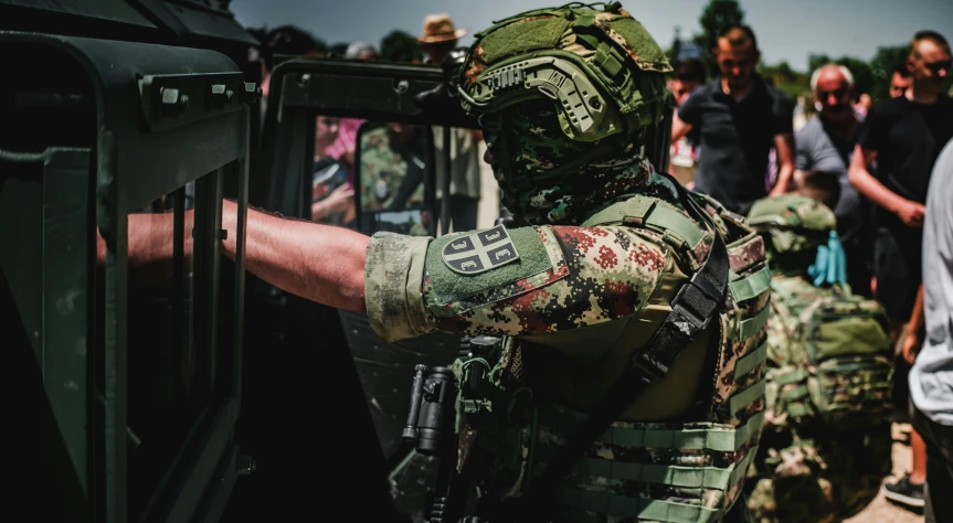 a man with a camouflaged suit getting out of a vehicle