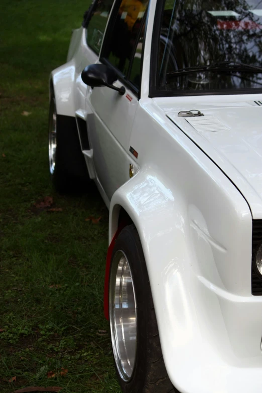 a white mercedes parked on top of green grass