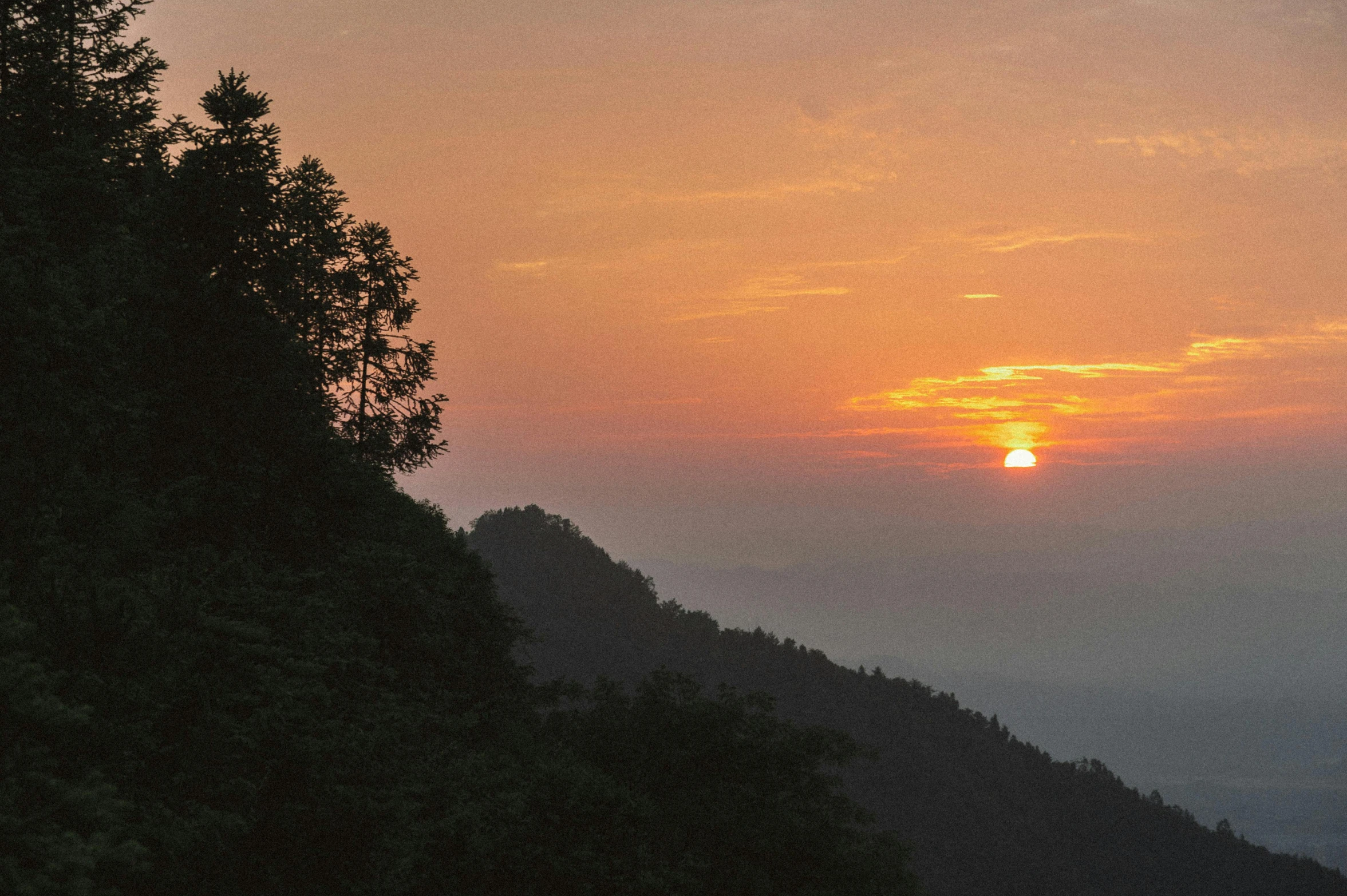 a view of a setting sun taken from a hill