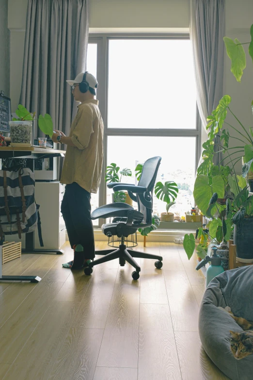 a person wearing a baseball hat and standing next to a chair