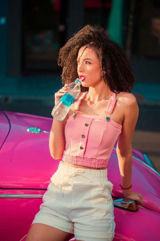 a beautiful woman standing next to a pink car