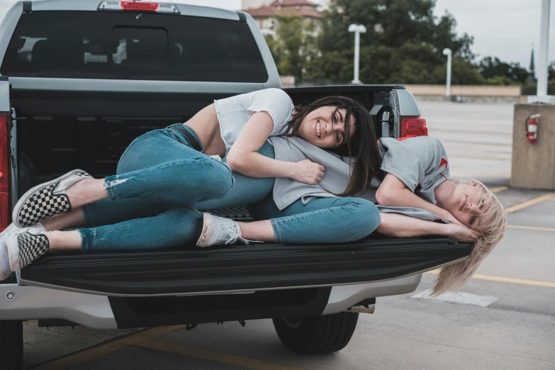 two young women lying on the back of a truck