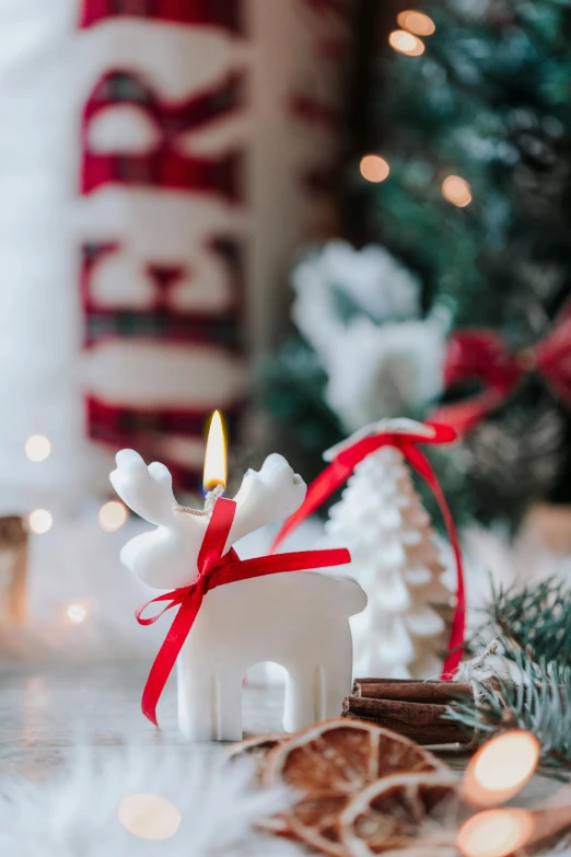 a white horse and a small candle are next to the christmas tree