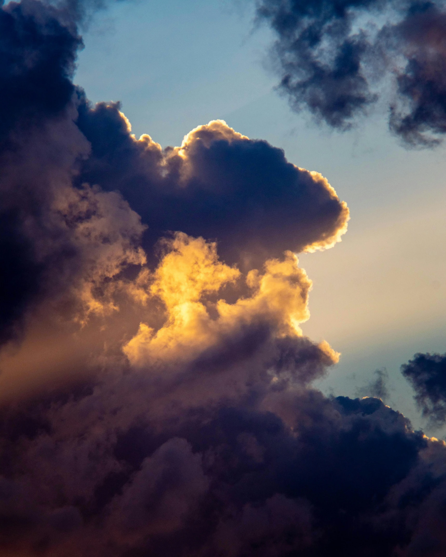 a plane flying through a cloudy sky next to other clouds