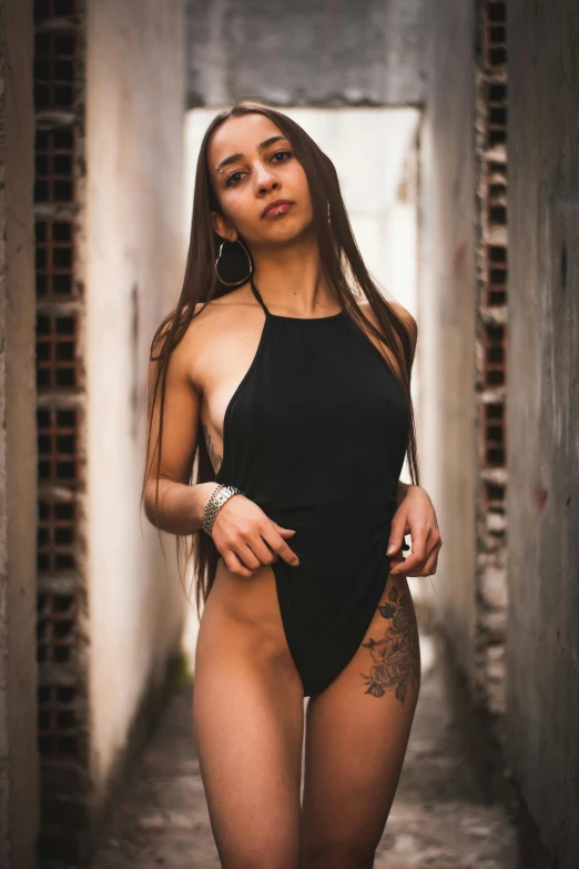 a woman wearing a one piece swimsuit in an alley