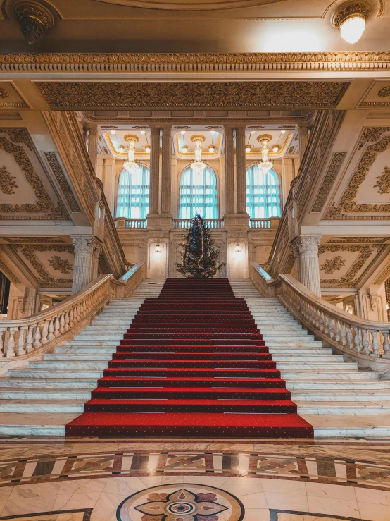 an elegant staircase in a historic building with red carpet