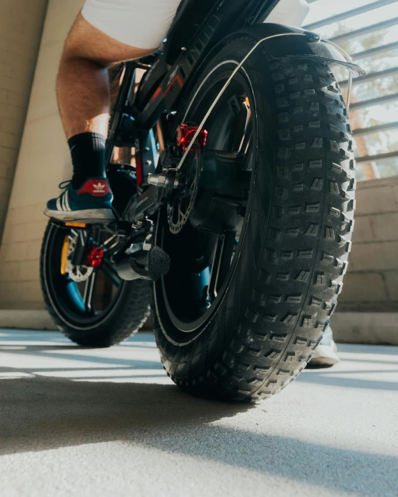 man's legs on bike next to glass windows