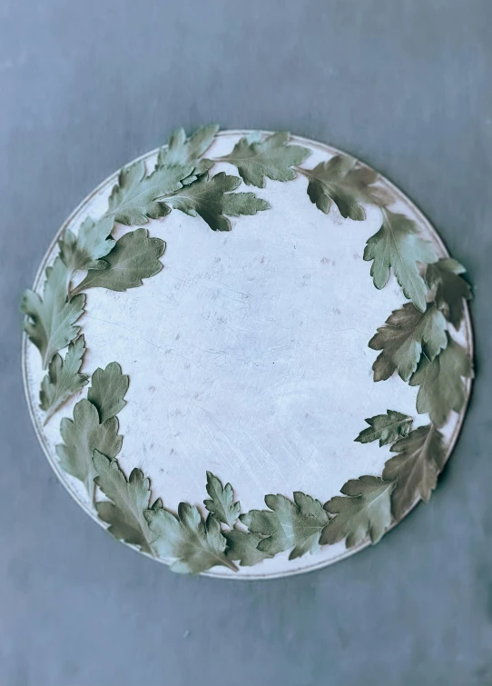 an empty plate decorated with green leaves