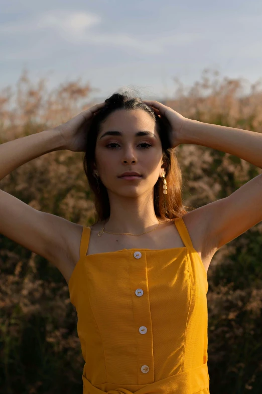 a young woman adjusts her hair outside