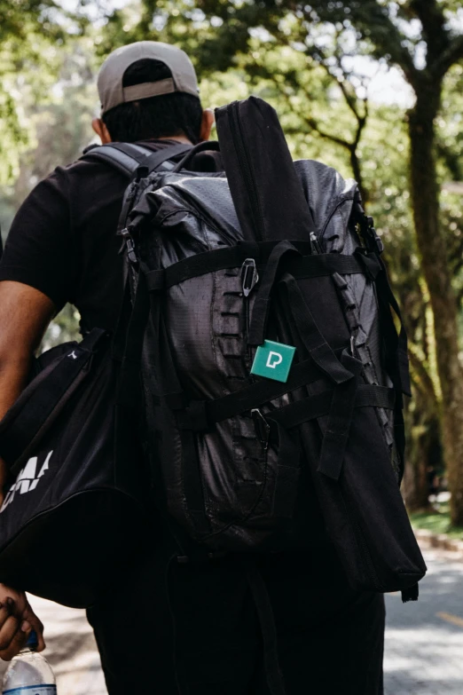 man walking down street with backpack back to camera