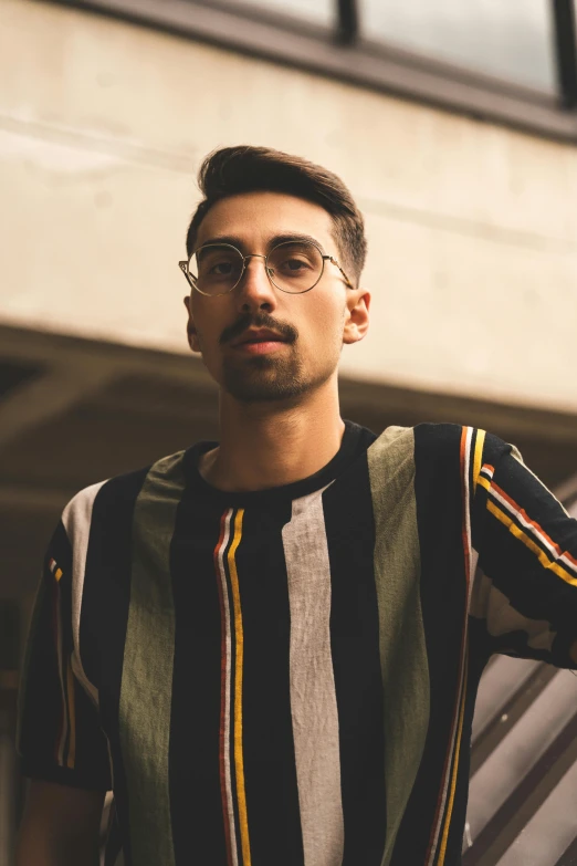 a man wearing glasses holding his hair up