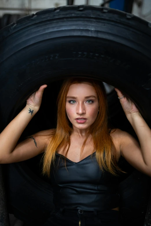 a woman standing inside a tire while holding the tires