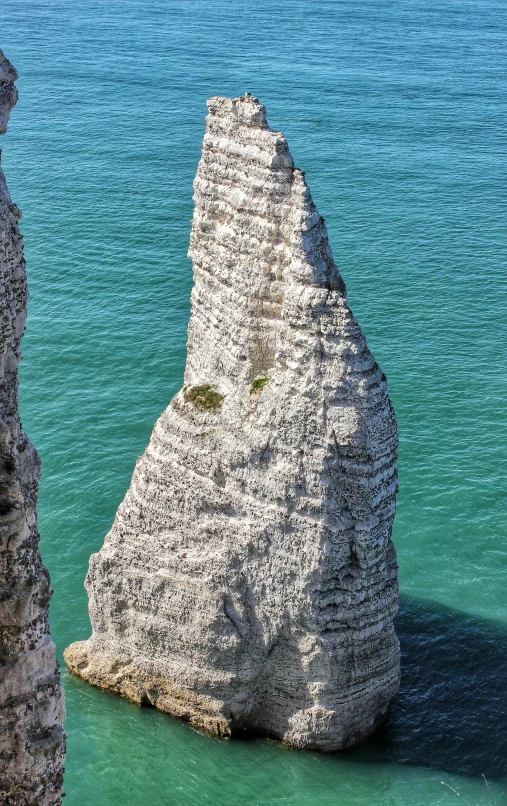 an unusual shaped rock sticking out of the water