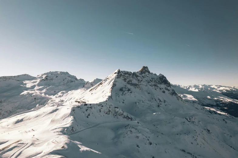 some snow and snow capped mountains with a sky background