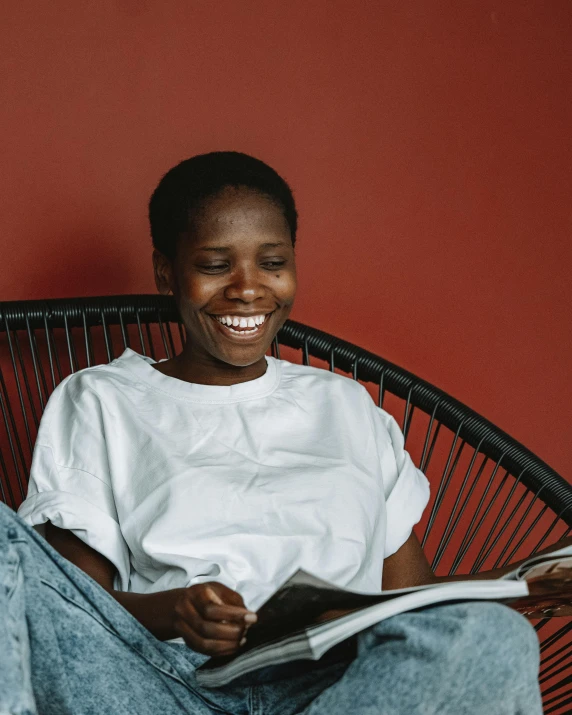 a man sitting in a black chair holding a newspaper