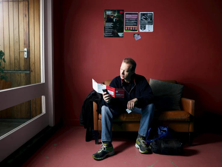 a man sits on a couch and reads