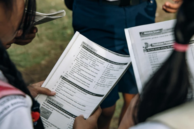 several people are holding paper and pointing at each other