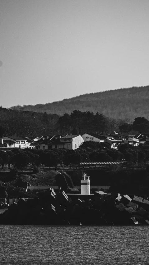 a lighthouse stands on the shore in black and white