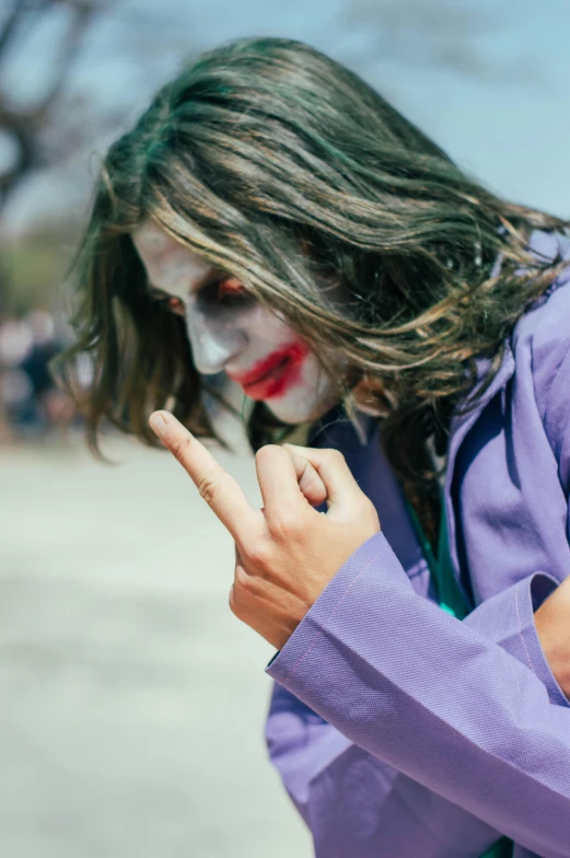 a man dressed as a clown making the v sign