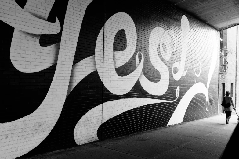 a man is walking by a large mural of coca cola