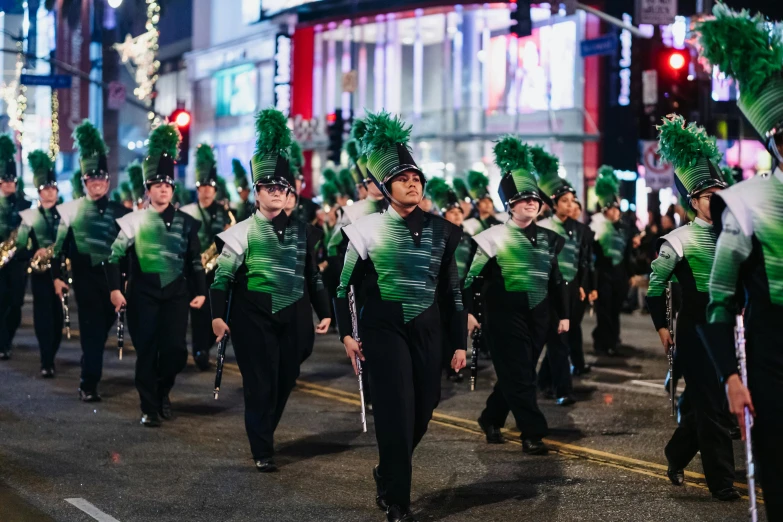 a parade on the street with people in green clothes