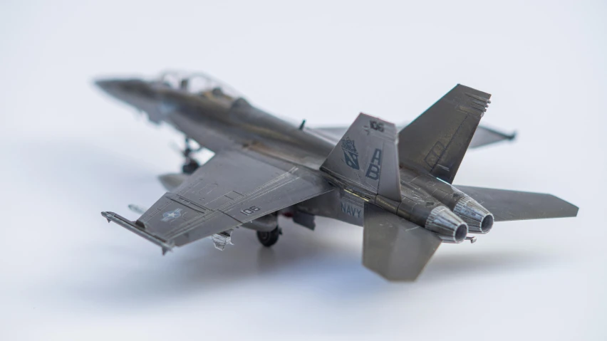 a military style model fighter plane against a gray background