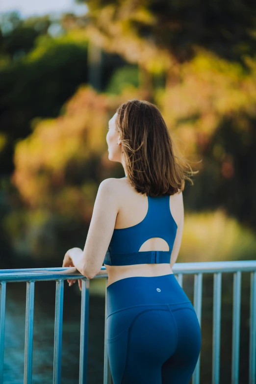 a young woman is standing by a railing near the water