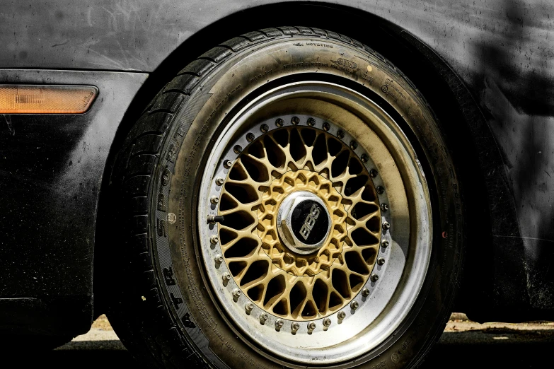 an image of a black car with gold spokes