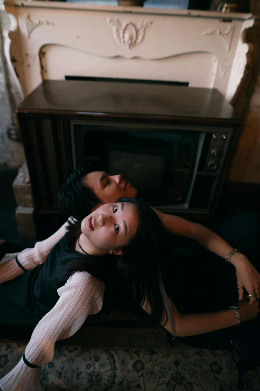 an image of a young man and woman in front of a fireplace