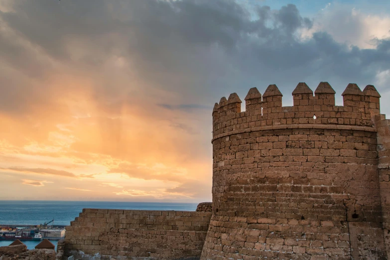 the old castle walls line the shoreline as the sun sets