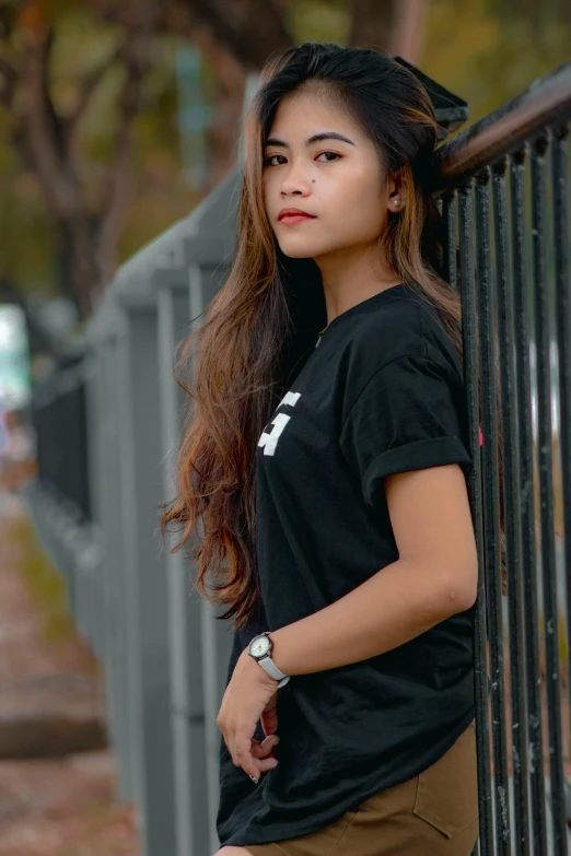 a woman with long hair leaning on the railing