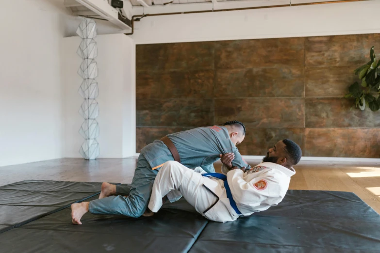 two men are doing a high - kicking position in the gym